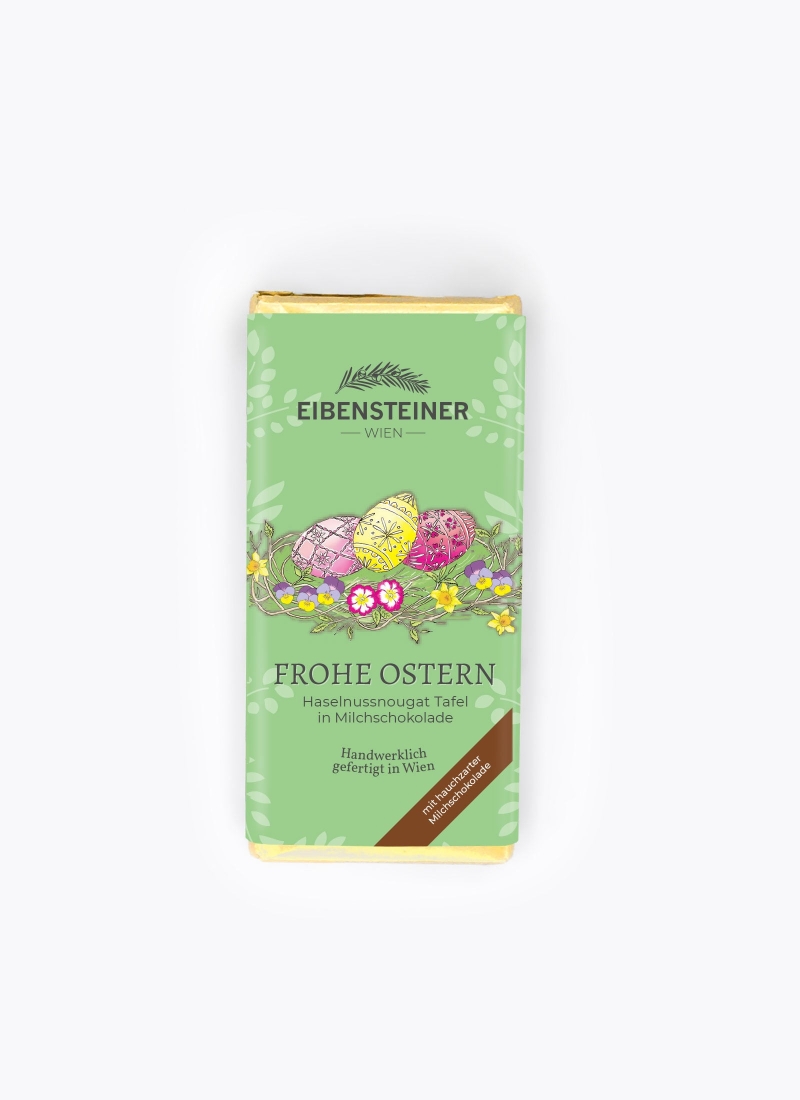 Frohe Ostern, Haselnussnougat Tafel in Milchschokolade, Eier, grüne Hintergrund